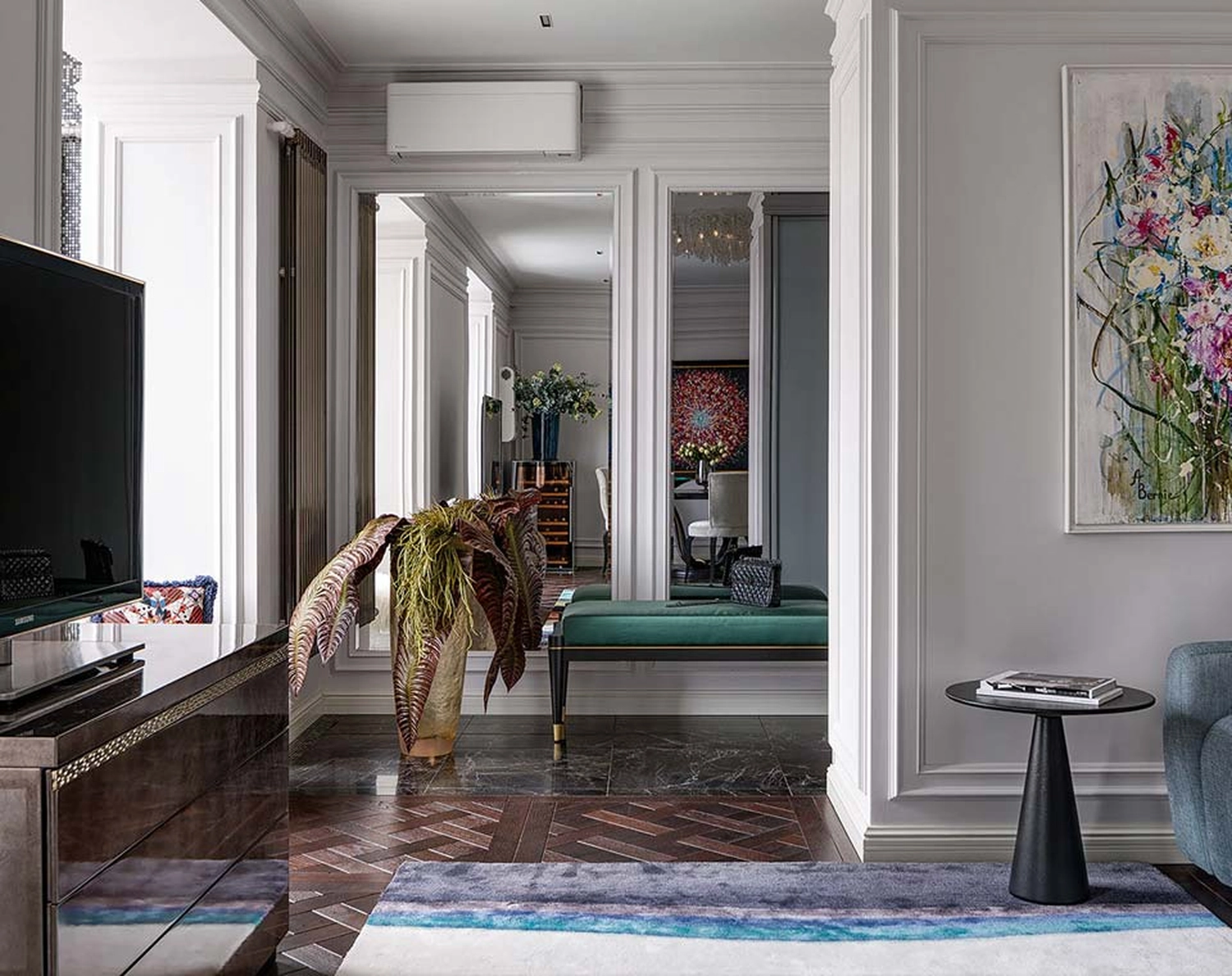 GM-Fensterbau - Fenster - Türen - Rollladen - Moderne Wohnzimmereinrichtung mit eleganten Wandleisten, einem strukturierten Akzentteppich, einem eleganten schwarzen Beistelltisch und einem großen Spiegel, in dem sich eine grüne Bank spiegelt.